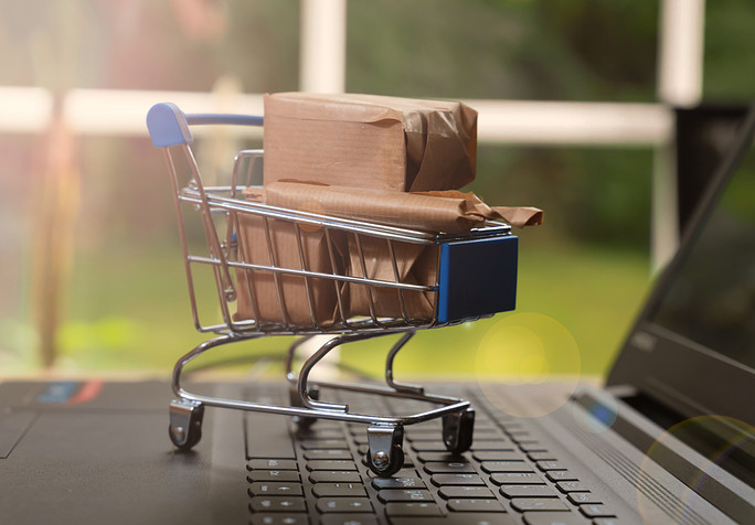 Shopping,Cart,With,Packaged,Boxes,Sitting,On,A,Laptop,Computer